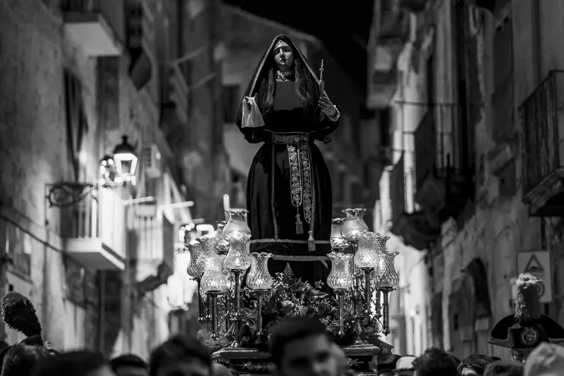 La statua di Santa Maria Maddalena illuminata dai lampioni durante la Processione dei Misteri del Venerdì Santo a Taranto.